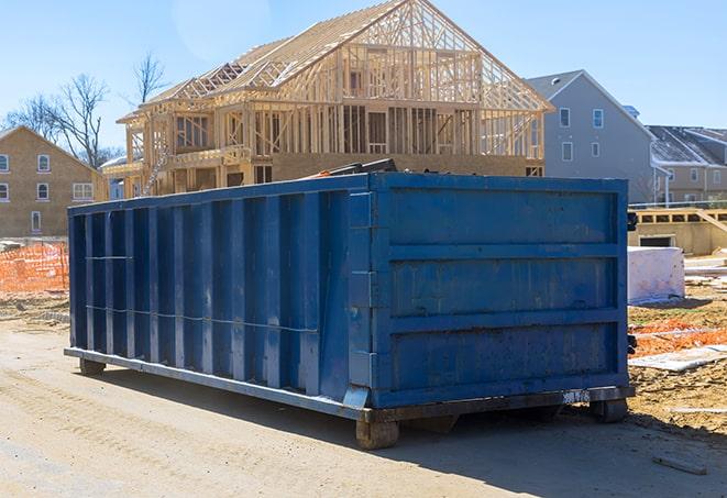 a bulldozer compacting a pile of debris inside of a residential dumpster